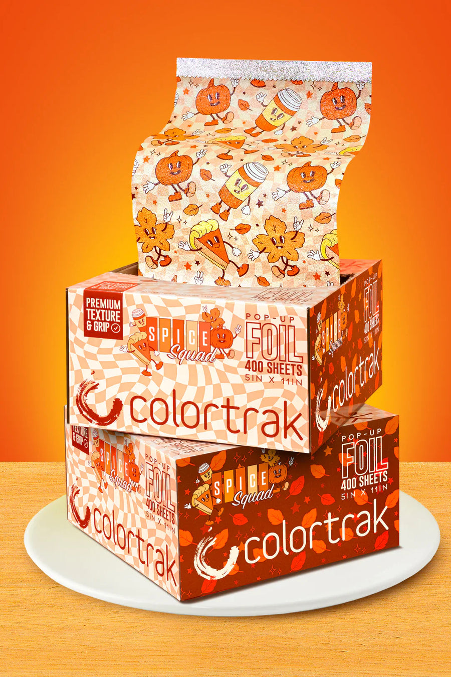 Stack of Colortrak foil boxes with Halloween-themed design on an orange background